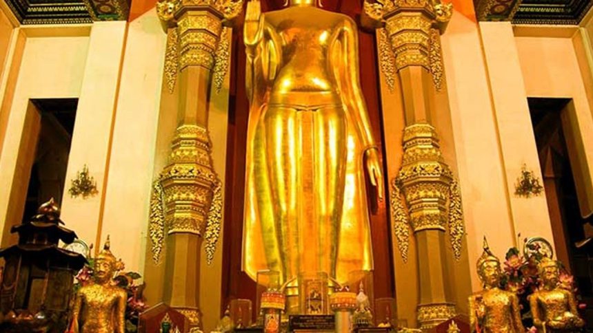 Grand bouddha debout doré dans un sanctuaire thaïlandais