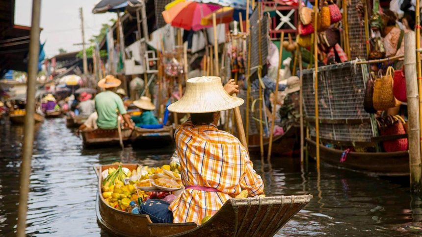 Vendeuse de fruits en barque sur le canal du marché flottant de Damnoen Saduak