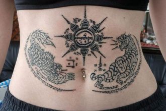 Sak yant traditionnel réalisé au Wat Bang Phra : tigres affrontés et diagrammes yantra
